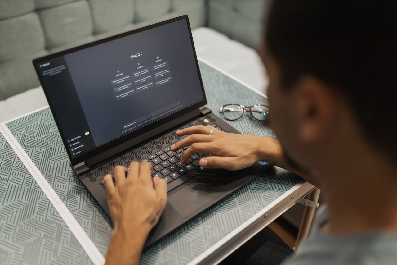 about-us A person using a laptop to interact with AI technology indoors during the day.